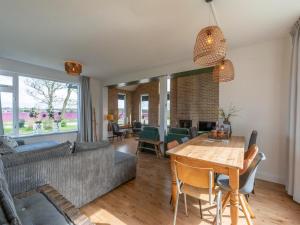 een woonkamer met een bank en een tafel bij Spacious Villa with garden in Callantsoog