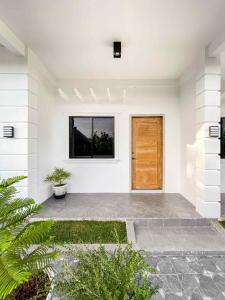 a front door of a white house with a wooden door at Cosy West Inn in Moalboal
