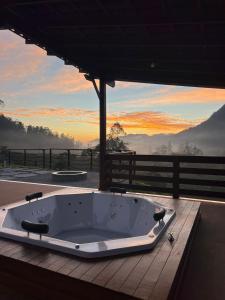 a bath tub sitting on top of a deck with a view at Refúgio Premium nas Montanhas de Alfredo Chaves Refúgio nas Montanhas de Alfredo Chaves com Piscina Jacuzzi Aquecida externa Suite Master com Hidro e Área Gourmet in Alfredo Chaves