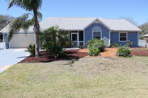 a blue house with a palm tree in a yard at Beach Blossum home in Saint Augustine