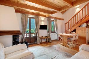 a living room with a table and a tv at Casa Caterina La Thuile in La Thuile