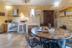 a large kitchen with a wooden table and chairs at Demeure Au Coeur De La Nature in Domme