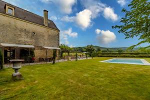 an old building with a yard and a swimming pool at Demeure Au Coeur De La Nature in Domme