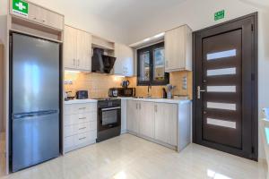 a large kitchen with a refrigerator and a door at Liθos Monemvasia in Yéfira