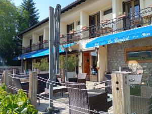 a building with chairs and tables in front of it at Le Boréal in La Bastide-de-Sérou
