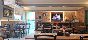 ein Restaurant mit Tischen und Stühlen und einem Fernseher an der Wand in der Unterkunft Blue Inn Hotel in Boa Vista