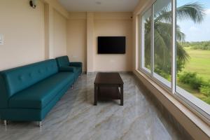un soggiorno con un divano blu e un tavolo di Casa D Village Wing 2 in Goa a Goa