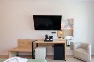 a room with a desk and a television on a wall at Hotel Parasol by Dorobe in Torremolinos