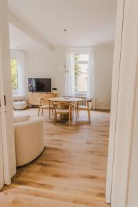 un soggiorno con un tavolo e un divano di City Suite Philosophenviertel - stylish & central a Hildesheim Altre 14 foto