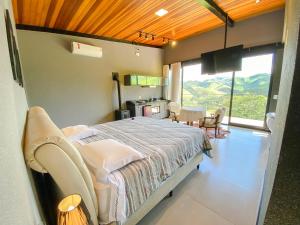 a bedroom with a bed and a table and chairs at Villa Mantiqueira SFX - Cabanas in São Francisco Xavier +71 photos