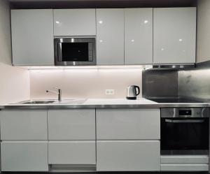 a kitchen with white cabinets and a sink and a microwave at les colibris in Passy
