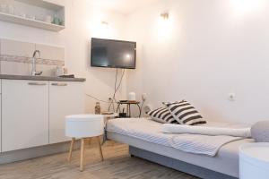 a living room with a couch and a tv on the wall at Apartment Ban in Šibenik