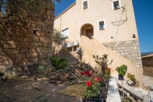 a stone building with flowers in front of it at Villa Solsticia in Albitreccia