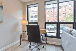 a office with a desk and a chair and a couch at Luxury 2BR North End Retreat in Boston +7 photos
