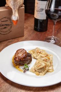 a plate of food on a table with a bottle of wine at Pousada Alto Da Boa Vista in Campos do Jordão