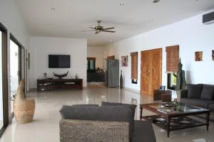 una sala de estar con un sofá y una mesa en Secluded Villa with Private Pool and Breathtaking Sea Views, en Ban Thong Phlu