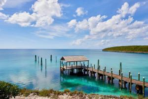 a dock in the water with a house on it at French Leave Resort, Autograph Collection in Governorʼs Harbour