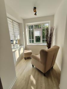 uma sala de estar com uma cadeira e uma janela em Ferienapartment am Dorfteich em Trebbin