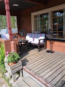 a wooden deck with a couch and a table at Lapikas in Kallo