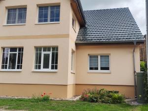 a house with windows and a trash can next to it at Ferienapartment am Dorfteich in Trebbin