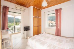 a bedroom with a bed and a desk and a window at Camaraki Lighthouse in Nydri
