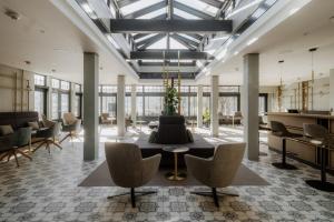 a lobby with a christmas tree on a table and chairs at Hotel Auerhahn am Schluchsee in Schluchsee