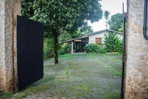 an open gate to a yard with a house at Saíra Recanto de Serra in Mulungu