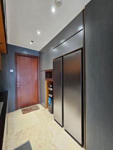 a kitchen with a large stainless steel refrigerator at Hegarmanah Residence Apartment in Bandung