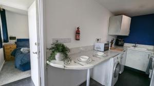WincobankにあるQuiet, Cozy Flat & Garden In Leafy Sheffield Areaのシンクと洗濯機付きのキッチン +1枚の写真