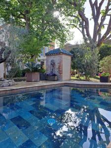 une piscine avec des carreaux bleus dans une cour dans l'établissement Les gites du tilleul, à Villefranche-de-Lauragais