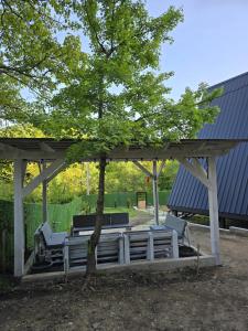 a gazebo with chairs and a tree at Cottage Meraki  +1 photo