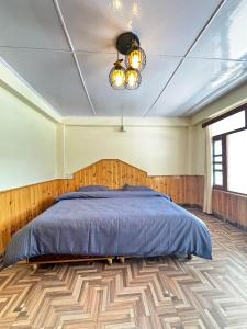 ein Schlafzimmer mit einem Bett und einem Holzboden in der Unterkunft Bayith Inn,dragon chowk in Manali + 2 Fotos