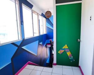 a bathroom with a green door with a kite on the wall at Hotel Velero Express in Iquique
