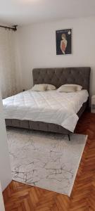 Un dormitorio con una cama grande con sábanas blancas. en Apartments Cinderella with City View, en Mostar