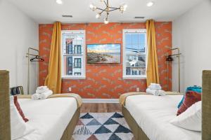 two beds in a room with orange walls and windows at Prime Old City Condo Free Parking Skyline Views in Philadelphia