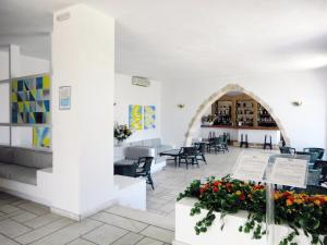 a restaurant with tables and chairs and flowers in a room at Patmos Paradise Hotel in Kámbos