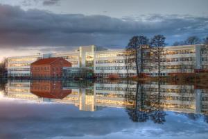 un edificio per uffici con il suo riflesso nell'acqua di Lovely apartment in the center of Ryd a Linköping