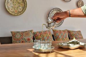 a person pouring water from a tea kettle on a table at La Casa De Mama in Marbella