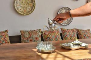 a person holding a tea pot on top of a table at La Casa De Mama in Marbella +53 photos