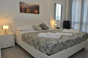 a bedroom with a bed and a desk with a lamp at Hotel Sikania in San Vito lo Capo