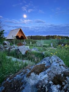 a gazebo in the middle of a field with rocks at Solkulla Matskog in Kulla