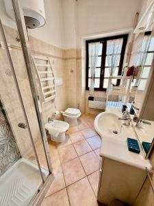 een badkamer met een toilet, een wastafel en een douche bij Casa Delfino - Appartamento Centro Storico a due passi dalla Spiaggia & Mare, Porto & Ferrovia in Civitavecchia