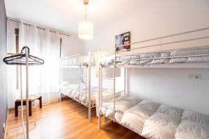 a room with two bunk beds and a couch at Little Yellow House in Gijón