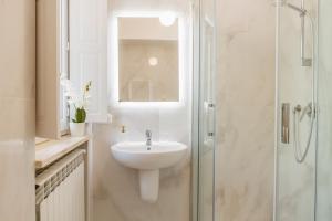 a white bathroom with a sink and a shower at Appartamenti Remota in Castiglione della Pescaia +44 photos
