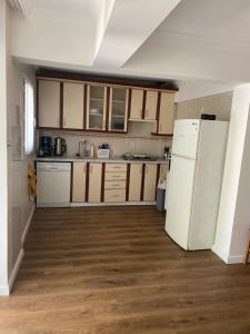 a kitchen with a white refrigerator and wooden floors at Villa Deja Blue in Karaburun