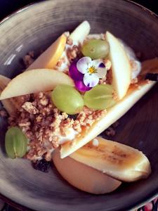 a plate of food with fruit and a flower on it at B&B De Geythoek in Sijsele