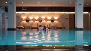 a couple sitting in a swimming pool at Casa Grande Hotel Resort & Spa in Guarujá