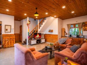 ein Wohnzimmer mit zwei Sofas und einem Kamin in der Unterkunft Moustache Select Mukteshwar in Mukteswar