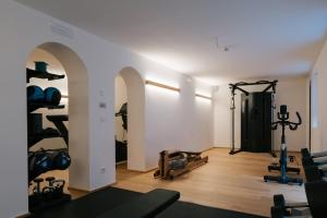 a room with a gym with weights and equipment at Hotel Fronza - your hike & mountain home in Lutago