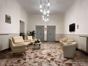 a living room with chairs and a table and a chandelier at Oasi Cuore in Castellammare di Stabia